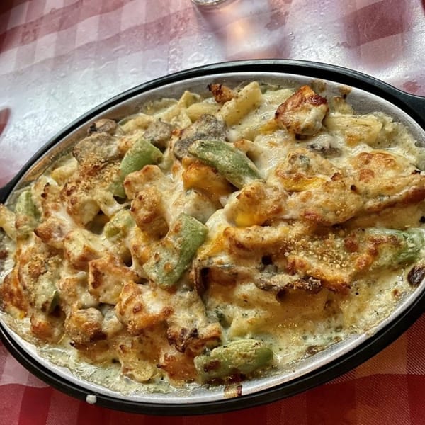 A baked Italian pasta dish with chicken, green peppers, and cheese in a creamy sauce.